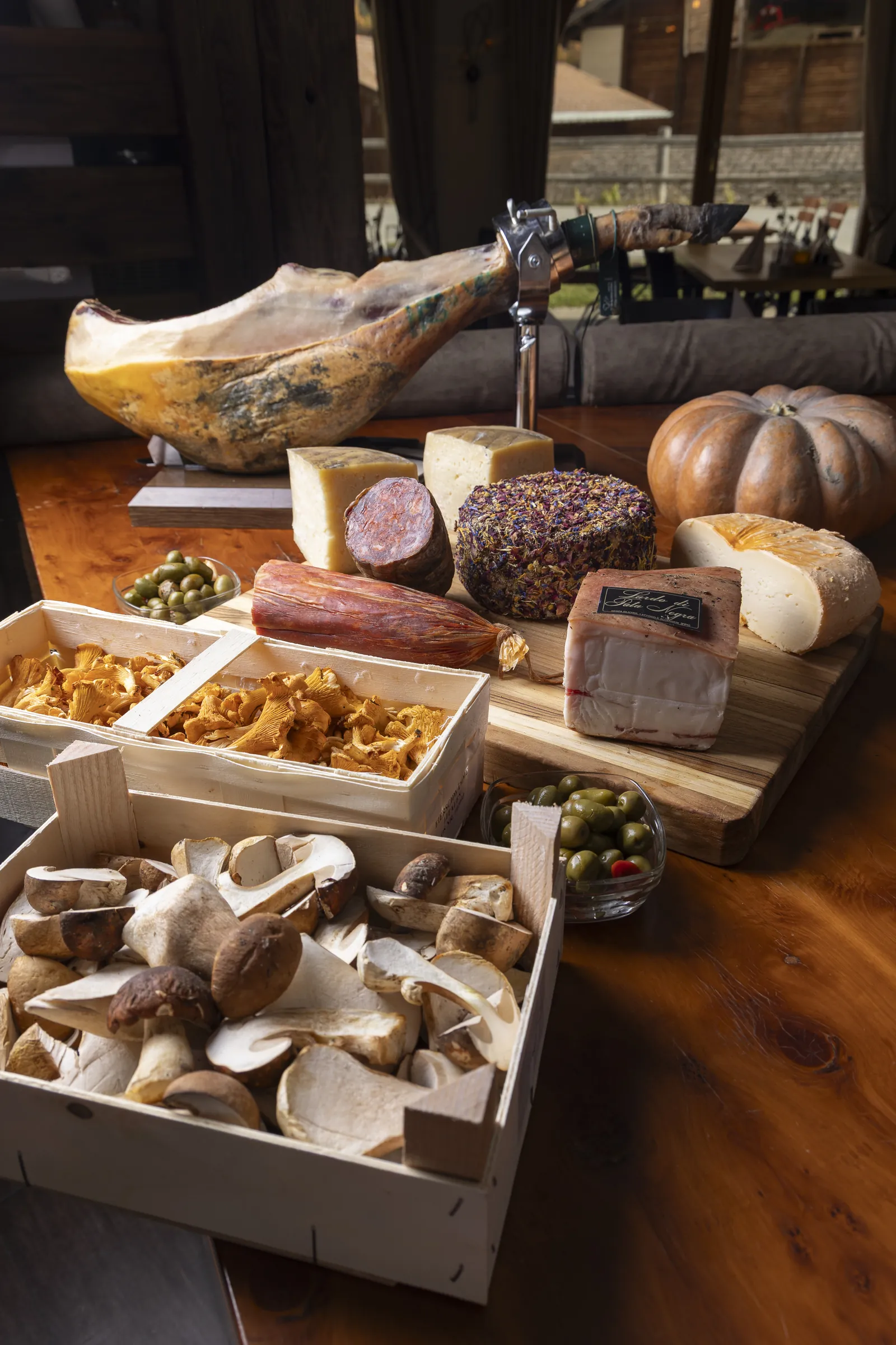 Jamón, spanischer Käse und Steinpilze auf dem Holztisch
