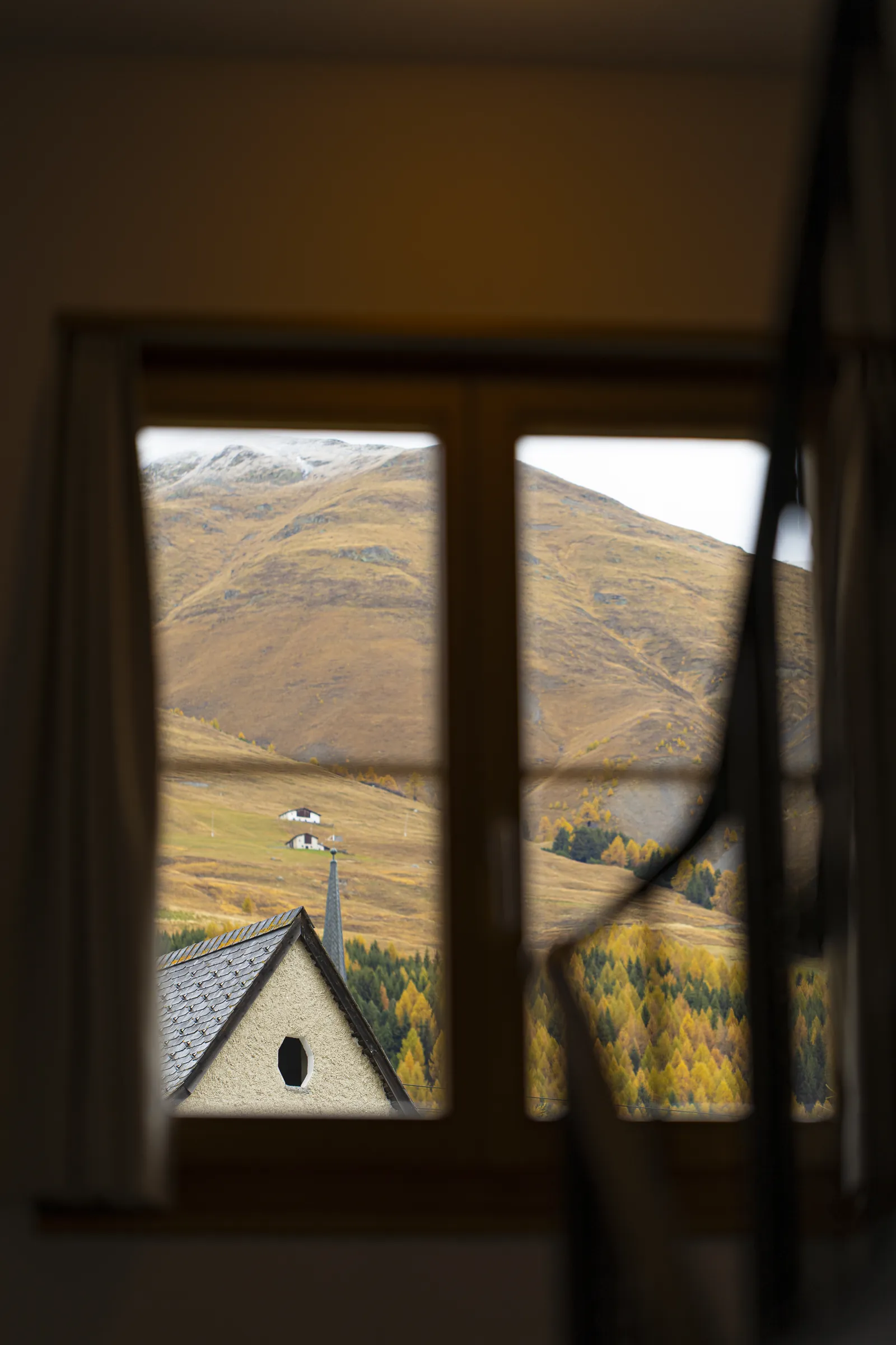 Blick aus dem Fenster auf die herbstlichen Berge von Zuoz